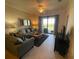 Inviting living room with comfortable seating, tile floors, and a sliding glass door to the outside at 7005 River Hammock Dr # 404, Bradenton, FL 34212