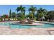 Stunning community pool with lounge chairs, potted plants, and mature palm trees at River Strand at 7005 River Hammock Dr # 404, Bradenton, FL 34212
