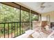 Relaxing screened porch with wicker furniture and lush garden views at 1700 Glenhouse Dr # 406, Sarasota, FL 34231