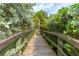 Wooden footbridge surrounded by lush tropical foliage at 1700 Glenhouse Dr # 406, Sarasota, FL 34231