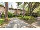 Exterior view of condo building, featuring a walkway, carport, and lush landscaping at 1700 Glenhouse Dr # 406, Sarasota, FL 34231