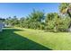 Large grassy backyard with lush landscaping and privacy at 4457 Maywood Ln, North Port, FL 34286