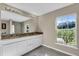 Double vanity bathroom with granite countertops and large mirror at 4457 Maywood Ln, North Port, FL 34286