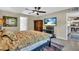 Main bedroom with king-size bed, ceiling fan, and view of kitchen at 4457 Maywood Ln, North Port, FL 34286