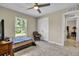 Bedroom with tiled floors, ceiling fan, window, and access to another room at 4457 Maywood Ln, North Port, FL 34286