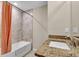 Bathroom with a bathtub, granite countertop, and peach-colored shower curtain at 4457 Maywood Ln, North Port, FL 34286