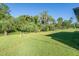Green grassy backyard with mature trees and privacy at 4457 Maywood Ln, North Port, FL 34286