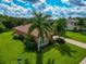 Aerial view of a beautiful house with palm trees and a well-manicured lawn at 111 172Nd E St, Bradenton, FL 34212