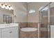 Bathroom with a soaking tub, walk-in shower, and white vanity at 111 172Nd E St, Bradenton, FL 34212