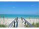 Wooden boardwalk leads to a beautiful beach with clear water at 2244 Palm Ter, Sarasota, FL 34231