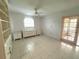 Well-lit bedroom with tile floors, a ceiling fan, built-in shelving and an access door to the screened porch at 6812 11Th W Ave # 6812, Bradenton, FL 34209