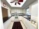 White kitchen featuring a skylight, black countertops, modern appliances, and a classic tile floor at 6812 11Th W Ave # 6812, Bradenton, FL 34209