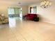 Bright living room featuring tile floors, red sofa, and a stylish chandelier, creating an inviting space at 6812 11Th W Ave # 6812, Bradenton, FL 34209