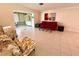 Bright living room with tile floors, floral armchairs, a red sofa and view to a sunroom at 6812 11Th W Ave # 6812, Bradenton, FL 34209