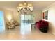 Bright living room featuring tile floors, red sofa, and a stylish chandelier, creating an inviting space at 6812 11Th W Ave # 6812, Bradenton, FL 34209