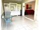 Bright sun room with tile floors and view to living room with red couch at 6812 11Th W Ave # 6812, Bradenton, FL 34209