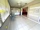 Bright sun room with tile floors and view to living room with red couch at 6812 11Th W Ave # 6812, Bradenton, FL 34209