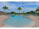 Relaxing freeform community pool with palm trees and lush landscaping at 7114 Quiet Creek Dr, Bradenton, FL 34212
