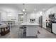 Open concept kitchen features white cabinets, stainless steel appliances, and an island at 383 Aruba Cir # 101, Bradenton, FL 34209