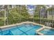 Enclosed pool and spa with a view of lush landscaping and a lake at 7049 Whitemarsh Cir, Lakewood Ranch, FL 34202