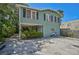 Light teal colored house with gravel driveway and mature palms at 1663 4Th St, Sarasota, FL 34236
