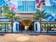 Modern building entrance with palm trees and brick pavement at 111 S Pineapple Ave # 1009, Sarasota, FL 34236