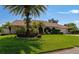 Single-story home with palm tree and well-manicured lawn at 225 Brighton Ct, Englewood, FL 34223