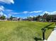 Expansive community green space framed by shops, under a vibrant blue sky with scattered clouds at 225 Brighton Ct, Englewood, FL 34223