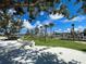 A modern playground with climbing structures and artificial turf, framed by lush trees and a bright blue sky at 225 Brighton Ct, Englewood, FL 34223