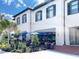 Outdoor patio seating area with blue umbrellas at a restaurant in Wellen Park with lush landscaping at 225 Brighton Ct, Englewood, FL 34223
