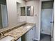 Bathroom with double sink vanity, granite countertop, modern mirrors, and tiled shower at 5278 Sabrina Ter, North Port, FL 34286