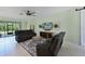 Beautiful living room featuring tile floors, a ceiling fan, and sliding glass doors to the lanai at 6622 Devesta Loop, Palmetto, FL 34221