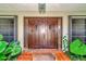Grand entrance with double wooden doors and lush landscaping at 225 Brighton Ct, Englewood, FL 34223
