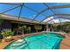 Relaxing pool and spa area with screened enclosure and lush landscaping at 225 Brighton Ct, Englewood, FL 34223