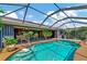 Relaxing pool and spa area with screened enclosure and lush landscaping at 225 Brighton Ct, Englewood, FL 34223