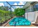 Relaxing hot tub with screened enclosure and lush tropical landscaping at 225 Brighton Ct, Englewood, FL 34223