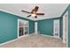 Bedroom with teal walls, tile flooring, and double doors leading outside at 225 Brighton Ct, Englewood, FL 34223