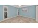 Light blue bedroom with tile floors and sliding glass doors to patio at 225 Brighton Ct, Englewood, FL 34223