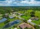 Aerial view showcasing a tranquil neighborhood with homes and a pond at 225 Brighton Ct, Englewood, FL 34223