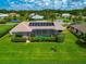 Aerial view of home with solar panels, pool, and lush landscaping at 225 Brighton Ct, Englewood, FL 34223