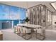 Elegant dining room with marble table, wine wall, and stunning water views at 555 Quay Cmn # 1503, Sarasota, FL 34236