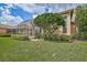 Landscaped backyard with lush lawn and screened patio at 7157 Del Lago Dr, Sarasota, FL 34238