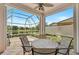 Relaxing screened patio with table and chairs, offering tranquil lake views at 7157 Del Lago Dr, Sarasota, FL 34238