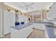 Open kitchen boasts white cabinets, an island, and views to Gathering room at 7157 Del Lago Dr, Sarasota, FL 34238