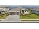 An aerial view of the front exterior of a home with a tile roof, three-car garage, and driveway at 15909 Tradewind Ter, Bradenton, FL 34211