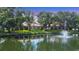 Tranquil backyard with a pond and fountain surrounded by mature trees at 3309 Highlands Bridge Rd # 58, Sarasota, FL 34235