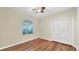 Bedroom with wood floors, closet, ceiling fan, and arched window at 3309 Highlands Bridge Rd # 58, Sarasota, FL 34235