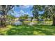Community lake view with fountain, green grass, mature trees, and several homes at 3309 Highlands Bridge Rd # 58, Sarasota, FL 34235