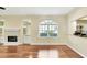 Living room with fireplace, wood floors, arched window, and view of the kitchen at 3309 Highlands Bridge Rd # 58, Sarasota, FL 34235