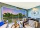 Relaxing lanai with wicker furniture, offering stunning sunset views over the water at 391 Aruba Cir # 302, Bradenton, FL 34209